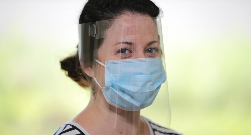 Woman in a face shield and medical mask