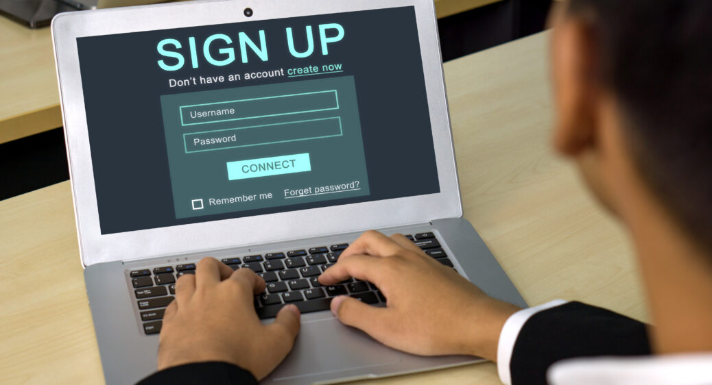 Male hands registering for an account on his laptop computer.