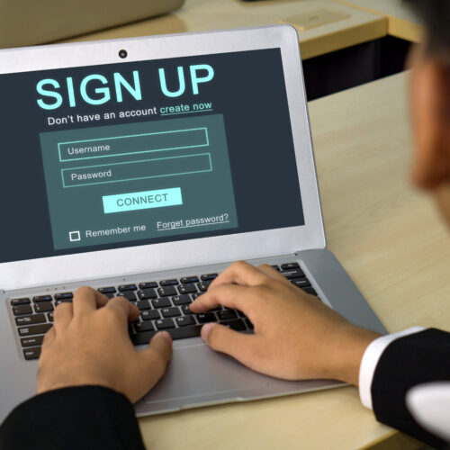 Male hands registering for an account on his laptop computer.