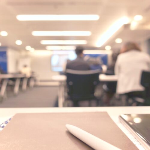 Abstract defocused photo of conference room with attendees background.